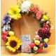Easter wreath made of fir and artificial flowers with polystyrene eggs, poisson and bunny,